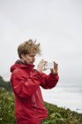 Man taking photo on cell phone at Big Sur in California, USA — Stock Photo