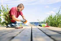 Mid adult man sawing deck, selective focus — Stock Photo