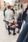 Мальчик-подросток держит мобильный телефон на городской улице — стоковое фото