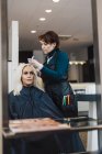 Hairdresser coloring client hair, selective focus — Stock Photo