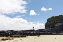 Женщина, гуляющая по пляжным скалам Шотландии — стоковое фото