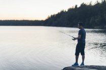 Человек рыбалка на озере, сосредоточиться на переднем плане — стоковое фото