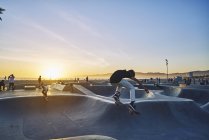 Seitenansicht eines Teenagers beim Skateboarden am Strand von Venedig, USA — Stockfoto