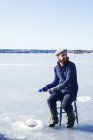 Man fishing on frozen lake in Dalarna, Sweden — Stock Photo