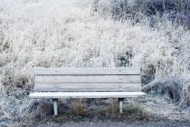 Wooden bench in snow, focus on foreground — Stock Photo