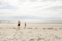 Hombre y chica caminando por la playa en Osterlen, Suecia - foto de stock