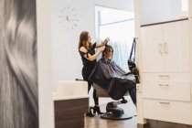 Coiffeur couper les cheveux des clients dans le salon, foyer sélectif — Photo de stock