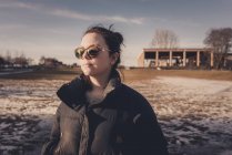 Женщина в солнечных очках зимой, сосредоточьтесь на переднем плане — стоковое фото