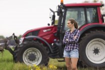 Работник сельского хозяйства, стоящий перед трактором, сосредоточьтесь на переднем плане — стоковое фото