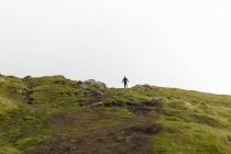 Мальовничий вид на пагорб, жінка стоїть на задньому плані — стокове фото