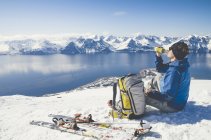 Vista laterale dello sciatore seduto sulla neve a Lyngen, Norvegia — Foto stock