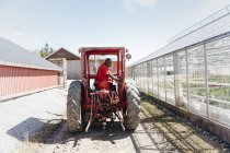 Работник садового центра на тракторе, селективный фокус — стоковое фото