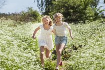 Zwei jugendliche mädchen rennen durch feld in blekinge, schweden — Stockfoto