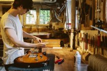 Craftsman working in guitar making workshop, selective focus — Stock Photo