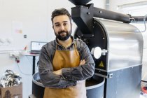 Small business owner with arms crossed at coffee roaster shop — Stock Photo