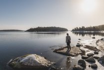 Человек, стоящий у озера, избирательный фокус — стоковое фото