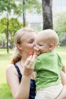 Mother kissing son, focus on foreground — Stock Photo