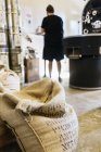 Coffee sacks in coffee roasting business, man in background — Stock Photo