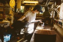 Artesano trabajando en taller de fabricación de guitarras - foto de stock