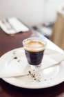 Caffè espresso su piatto, fondo soft focus — Foto stock