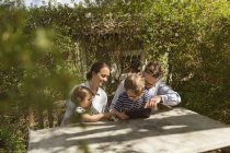 Happy family sitting at outdoor table, focus on foreground — Stock Photo