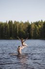 Homme jetant adolescent garçon dans le lac à Kilsbergen, Suède — Photo de stock