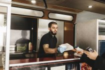 Работник грузовика с едой обслуживания клиентов, выборочный фокус — стоковое фото