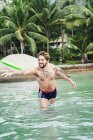 Young man throwing frisbee in swimming pool in Koh Samui, Thailand — Stock Photo