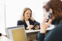 Woman using smart phone in background, selective focus — Stock Photo