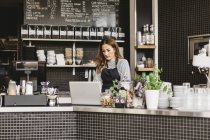 Barista using laptop at cafe counter, selective focus — Stock Photo