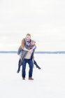 Junges Paar spielt im Schnee, Fokus auf den Vordergrund — Stockfoto