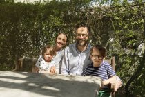 Щаслива сім'я сидить за відкритим столом, фокус на передньому плані — стокове фото