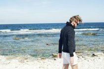 Jeune homme marchant sur la plage à Gotland, Suède — Photo de stock