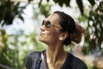 Woman in sunglasses looking away, focus on foreground — Stock Photo