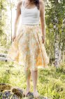 Cropped view of young woman wearing floral skirt outdoors — Stock Photo
