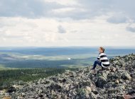 Frau sitzt auf Felsen in Kittila, Finnland — Stockfoto
