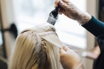 Clientes cabelo sendo iluminado no cabeleireiro, foco em primeiro plano — Fotografia de Stock
