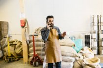 Власник малого бізнесу в кав'ярні, що розмовляє на мобільному телефоні — стокове фото