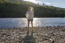 Mitte erwachsene Frau steht neben klaralven river in schweden — Stockfoto