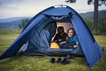 Enfants dans la tente dans la prairie, se concentrer sur le premier plan — Photo de stock