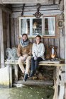 Junges Paar sitzt auf Holztisch — Stockfoto