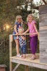 Schwestern mit Bruder auf Baumhaus-Veranda, Fokus auf Vordergrund — Stockfoto