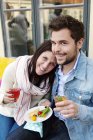 Happy couple with food outdoors, focus on foreground — Stock Photo