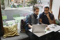 Young men working together in cafe, selective focus — Stock Photo