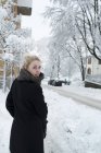 Молода жінка на сніговій вулиці, зосередься на передньому плані. — стокове фото
