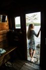 Jeune femme en maison d'été avec lac en arrière-plan — Photo de stock