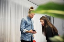 Junge männliche und weibliche Mitarbeiter nutzen Smartphone und arbeiten im Büro — Stockfoto