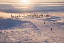 Menschen, die bei Sonnenuntergang Ski fahren, selektiver Fokus — Stockfoto