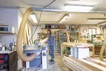 Плотник держит древесину в мастерской — стоковое фото