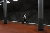 Junge Frau mit Koffer an U-Bahnhof — Stockfoto